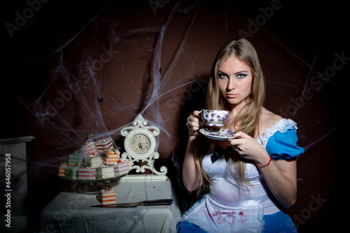 Halloween. Portrait of a young woman with a large kitchen knife. Dressed as Alice photo