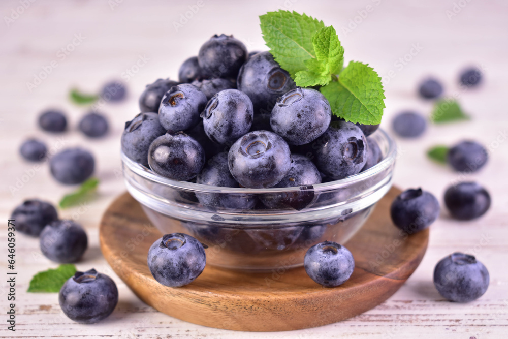 Fresh blueberries in a glass bowl on a white background.Close-up. Fresh blueberries in a glass bowl on a white background.Close-up.