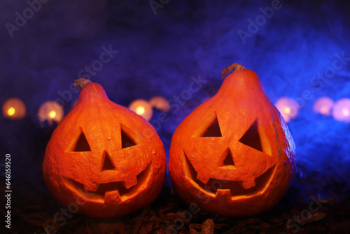 Two pumpkins with blue light and smoke