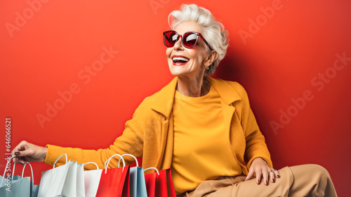 Elegant modern age woman holding shopping bags, bright background. Concept of shopping, sales season, Black Friday