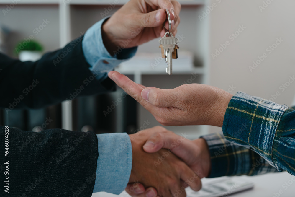 A real estate agent is talking with a client about buying a home or getting home insurance. Real estate agent buys, sells a house, agrees to buy a house.