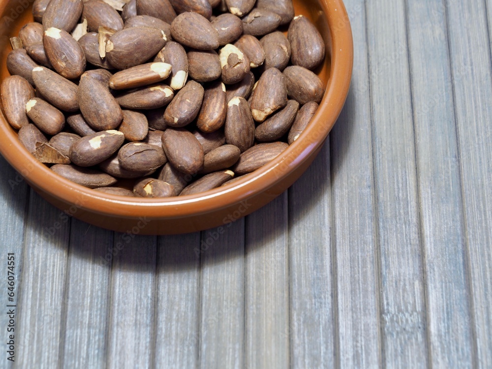 detail of a roasted almond bowl on a wooden table detail of a roasted almond bowl on a wooden table
