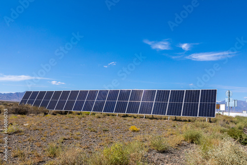 Solar panels in a rocky desert against a blue sky