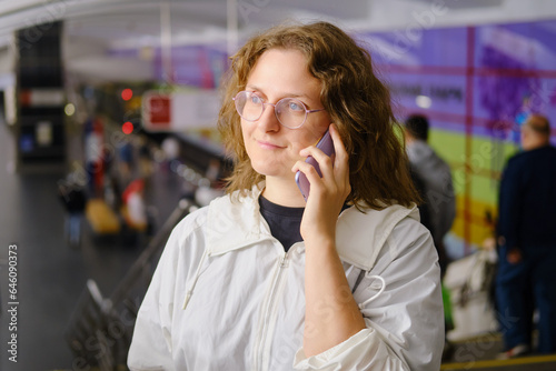 Young woman talking on the phone in the subway, close-up