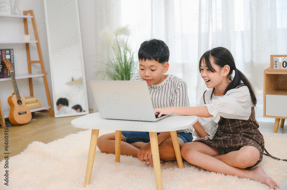 Asian girl and boy using laptop computer study online at home happy students with education typing on keyboard looking at pc screen Watch Webinars Online Courses Do Homework Asian girl and boy using laptop computer study online at home happy students with education typing on keyboard looking at pc screen Watch Webinars Online Courses Do Homework