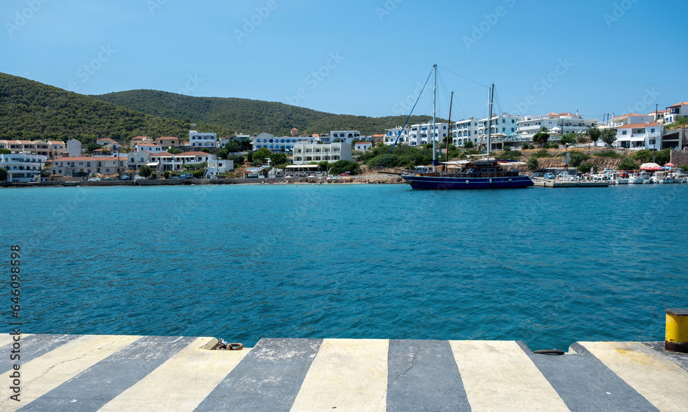 Greece, Megalochori, Milos, Miloi port, Agistri island. Harbor with bollard, calm sea, blue sky.