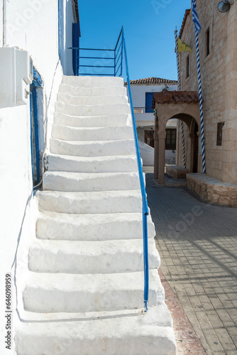Megalochori, Milos, Miloi village Agistri island Greece. White stairway, church, sunny day. Vertical