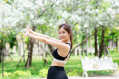 Young woman exercising and stretching in the park. Female Jogging and Doing Fitness Exercises in the City Park.