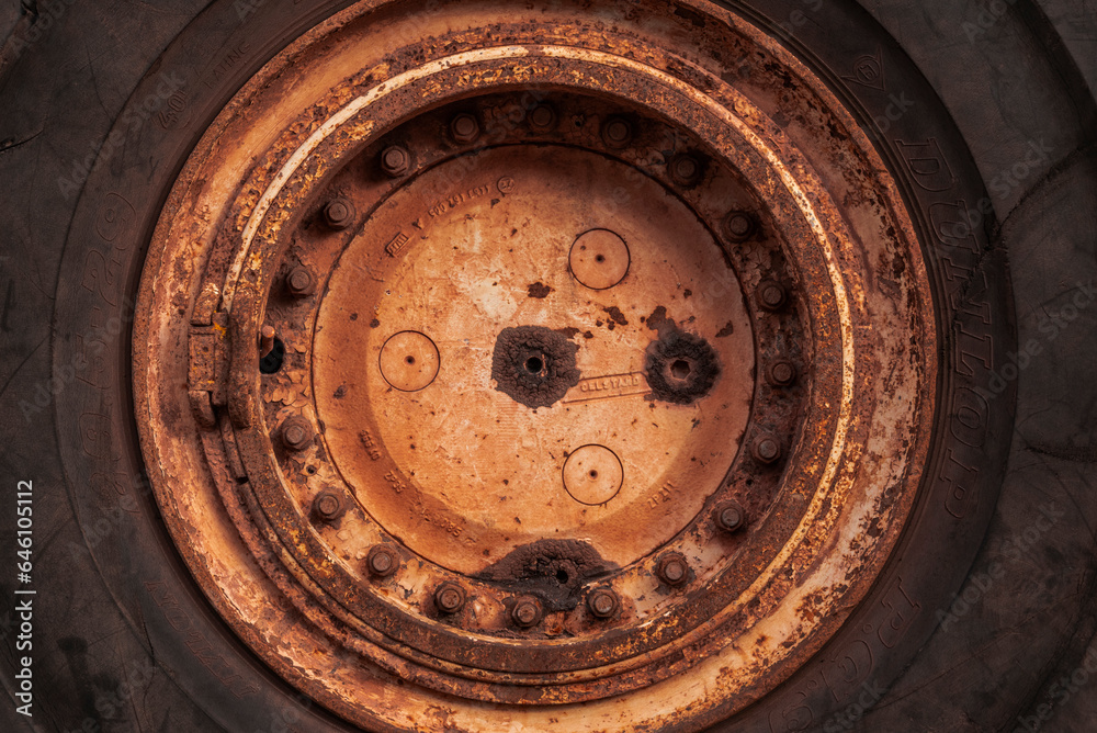 Full frame circular background texture of the huge rubber tire and rusted rim of an old mining truck