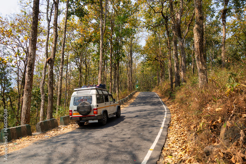 A tourist vehicle travels along a scenic mountain road on way to Darjeeling in West Bengal, India
