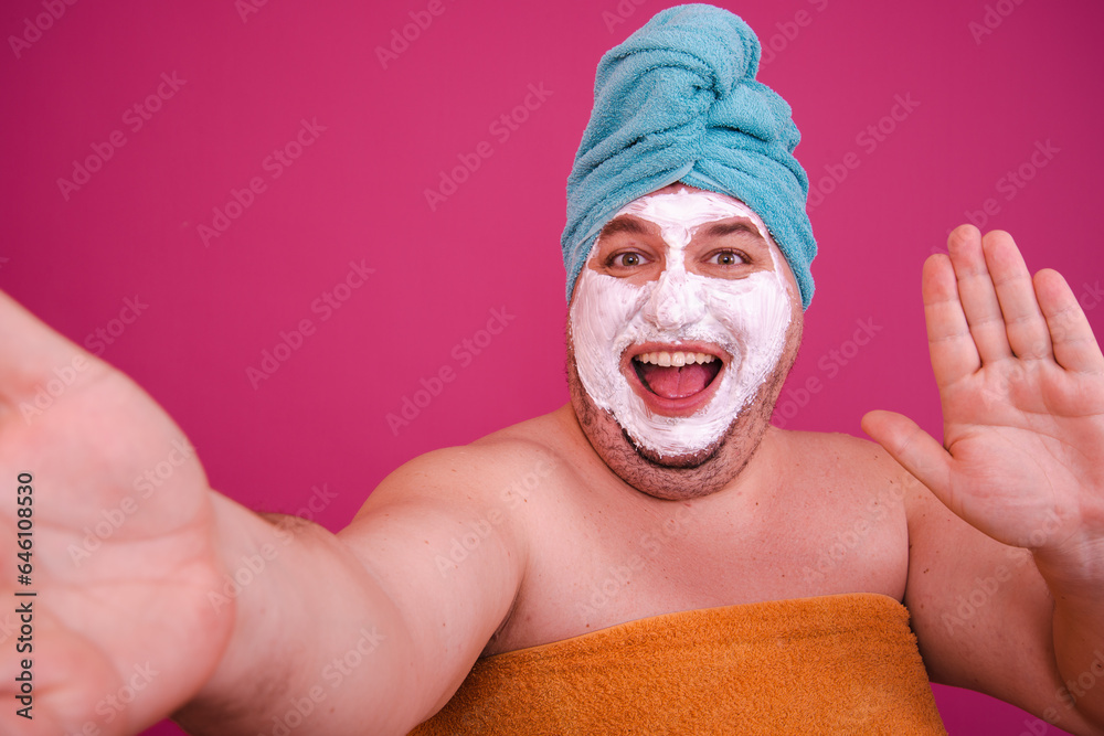 Early morning. Funny fat man after a shower getting ready for a party. Pink background. Early morning. Funny fat man after a shower getting ready for a party. Pink background.