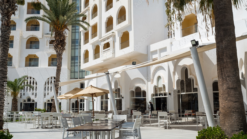 Facade of an arab style luxury hotel with palms trees.