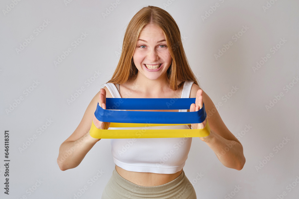 Sport Woman performs exercises for the arm muscles. Woman work with resistance band. Health and sport concept. Strength and motivation Sport Woman performs exercises for the arm muscles. Woman work with resistance band. Health and sport concept. Strength and motivation