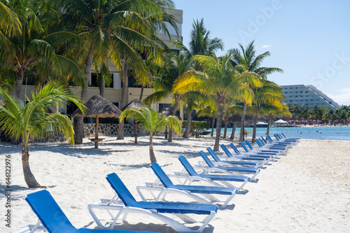 Fototapeta Naklejka Na Ścianę i Meble -  Row of sunbeds on sandy beach. Cancun resorts