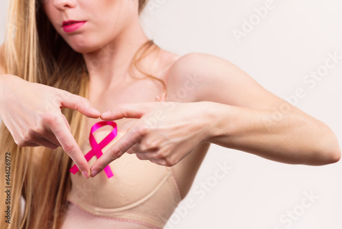 Woman with pink cancer ribbon on breast