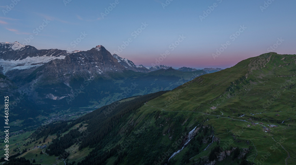 View on the Eiger Nordwand and other famous Swiss Alpine mountains during sunrise on a summer morning, as seen from the mountain hut First on First mountain. early morning sunrise in Switzerland.