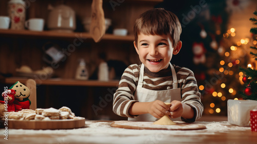 Cute little boy making gingerbread cookies in christmas decorated kitchen