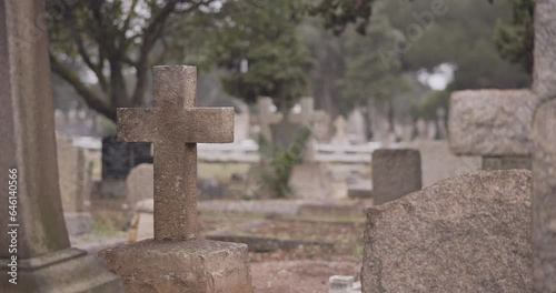 Funeral, cemetery and cross on tombstone for death ceremony, religion or memorial service. Catholic symbol, background or Christian sign on gravestone for mourning, burial or loss in public graveyard
