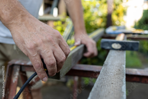 Mans hands preparing wood for processing 