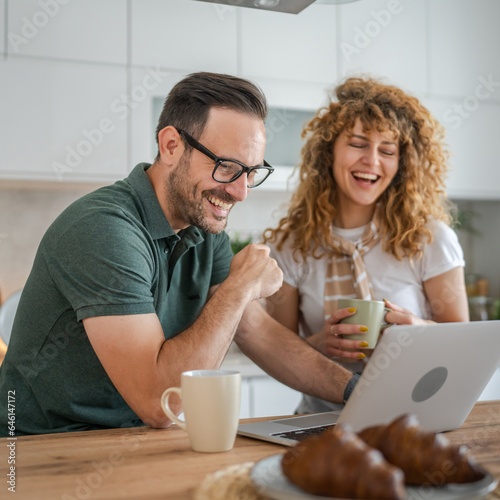 happy couple man and woman husband and wife morning routine use laptop