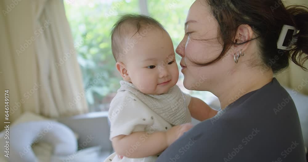 Close up portrait young mother hold in arms hug cuddle little cute baby girl toddler and kiss, loving Asian mom embrace small baby child, relax enjoy tender family moment Motherhood concept Close up portrait young mother hold in arms hug cuddle little cute baby girl toddler and kiss, loving Asian mom embrace small baby child, relax enjoy tender family moment Motherhood concept