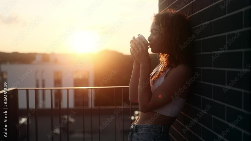 Portrait of stunning young woman take sip drinking hot tea or coffee with beautiful sunset or sunrise at home balcony Calm relaxed female enjoying leisure time alone indoors Portrait of stunning young woman take sip drinking hot tea or coffee with beautiful sunset or sunrise at home balcony Calm relaxed female enjoying leisure time alone indoors