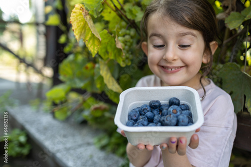 Cute four years girl with blueberries 