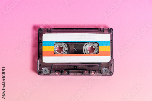 Fotografija Transparent audio cassette with labels on fuchsia background.