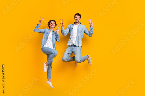 Full length photo of crazy funky cheerful people stylish jeans clothes have fun black friday sale isolated on yellow color background