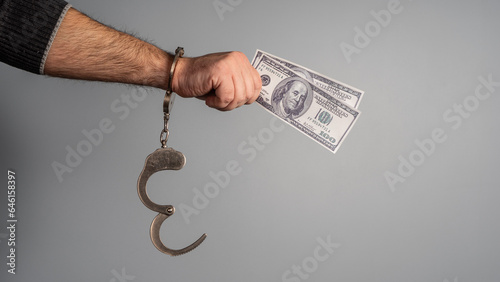 hands in handcuffs hold money photo