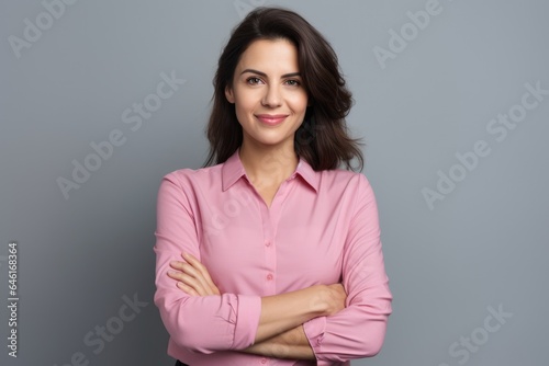 Happy young smiling confident professional business woman wearing pink shirt, pretty stylish female executive looking at camera, standing arms crossed isolated at gray background, 