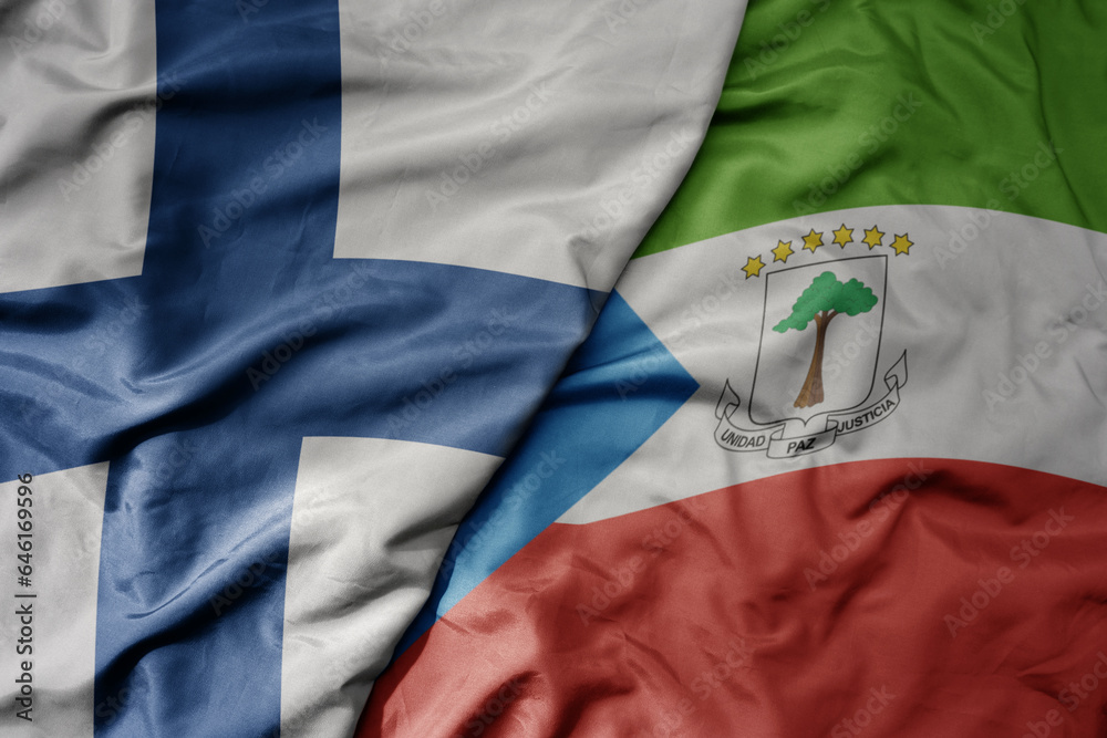 big waving national colorful flag of finland and national flag of equatorial guinea .