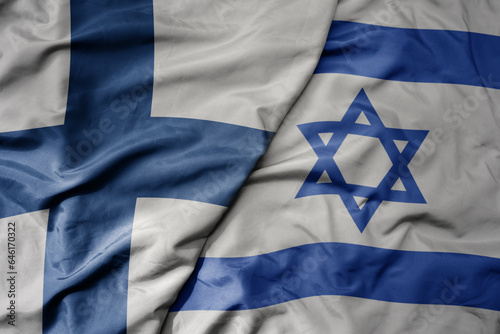 big waving national colorful flag of finland and national flag of israel .