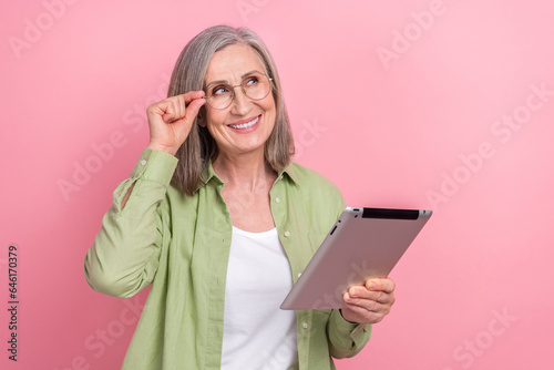 Photo of smart business manager woman specs looking very intelligent hold web tablet dreaming mockup isolated on pink color background