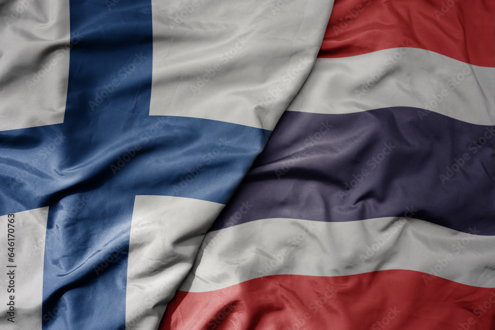 Obraz premium big waving national colorful flag of finland and national flag of thailand .