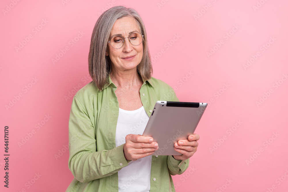 Photo of pensioner middle age pensioner woman working remote call video tablet marketing analyzing isolated on pink color background Photo of pensioner middle age pensioner woman working remote call video tablet marketing analyzing isolated on pink color background