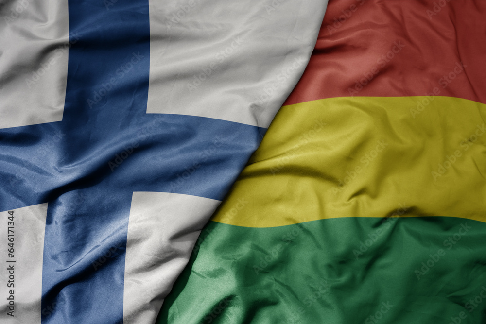 big waving national colorful flag of finland and national flag of bolivia .