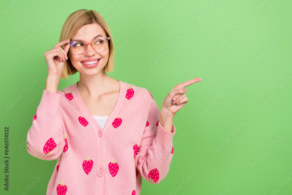 Photo of pretty young girl point look empty space specs dressed stylish pink strawberry print outfit isolated on green color background Photo of pretty young girl point look empty space specs dressed stylish pink strawberry print outfit isolated on green color background