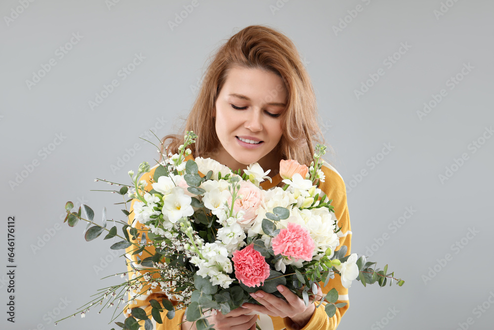 Beautiful woman with bouquet of flowers on grey background Beautiful woman with bouquet of flowers on grey background