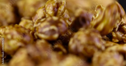 pour delicious sweet popcorn with lots of caramel, caramel flavor of popcorn close-up photo