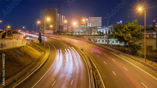 Time-lapse of street traffic near Campolide station in the evening with car lights trails. Lisbon, Portugal. Zoom out effect photo