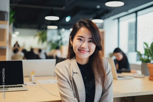 Smiling portrait of a happy korean woman working for a modern startup company in a business office