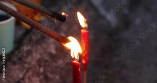 Lilting flame on joss sticks from candle flame for burning on Chinese hungry ghost festival 