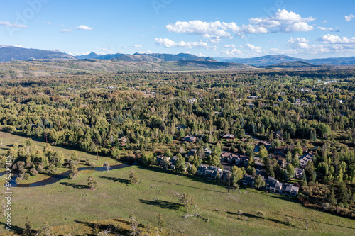 Aerial View of a Forested Subdivision in Wilson Wyoming next to a Ranch with Pasture Land photo