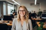 Smiling portrait of a happy young caucasian woman working for a modern startup company in a business office
