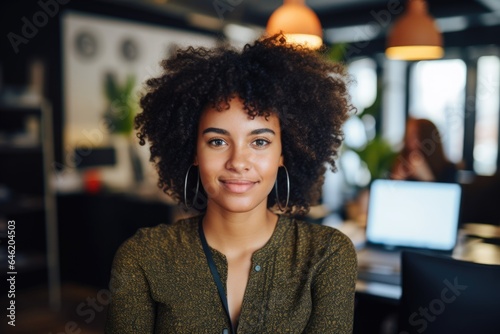 Smiling portrait of a happy young african american woman working for a modern startup company in a business ofice