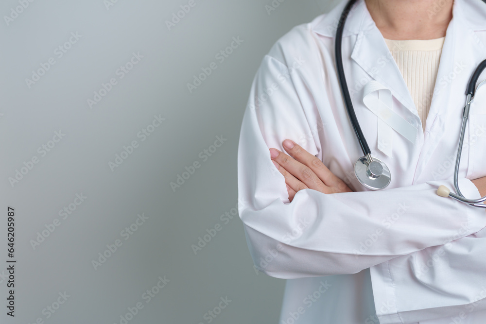 November Lung Cancer Awareness month. Doctor with White ribbon in hospital. Healthcare and World Cancer day concept