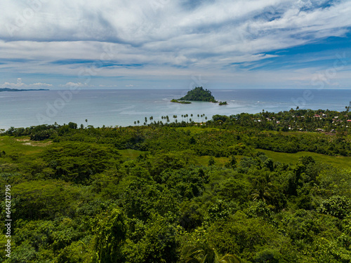 Aerial view of tropical island with green trees under clear sky and clouds. Davao Oriental, Philippines. photo