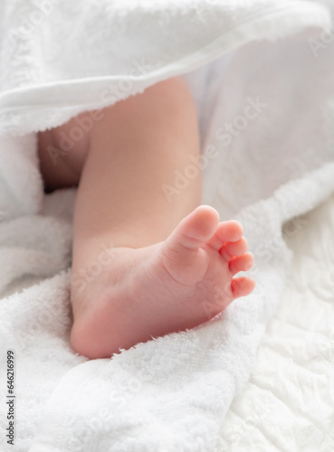 Whispers of life: baby's foot tiptoeing out from a towel