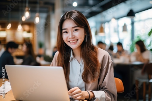Asian japanese chinese student girl smile using notebook laptop  woman studying online hybrid learning in coworking third space